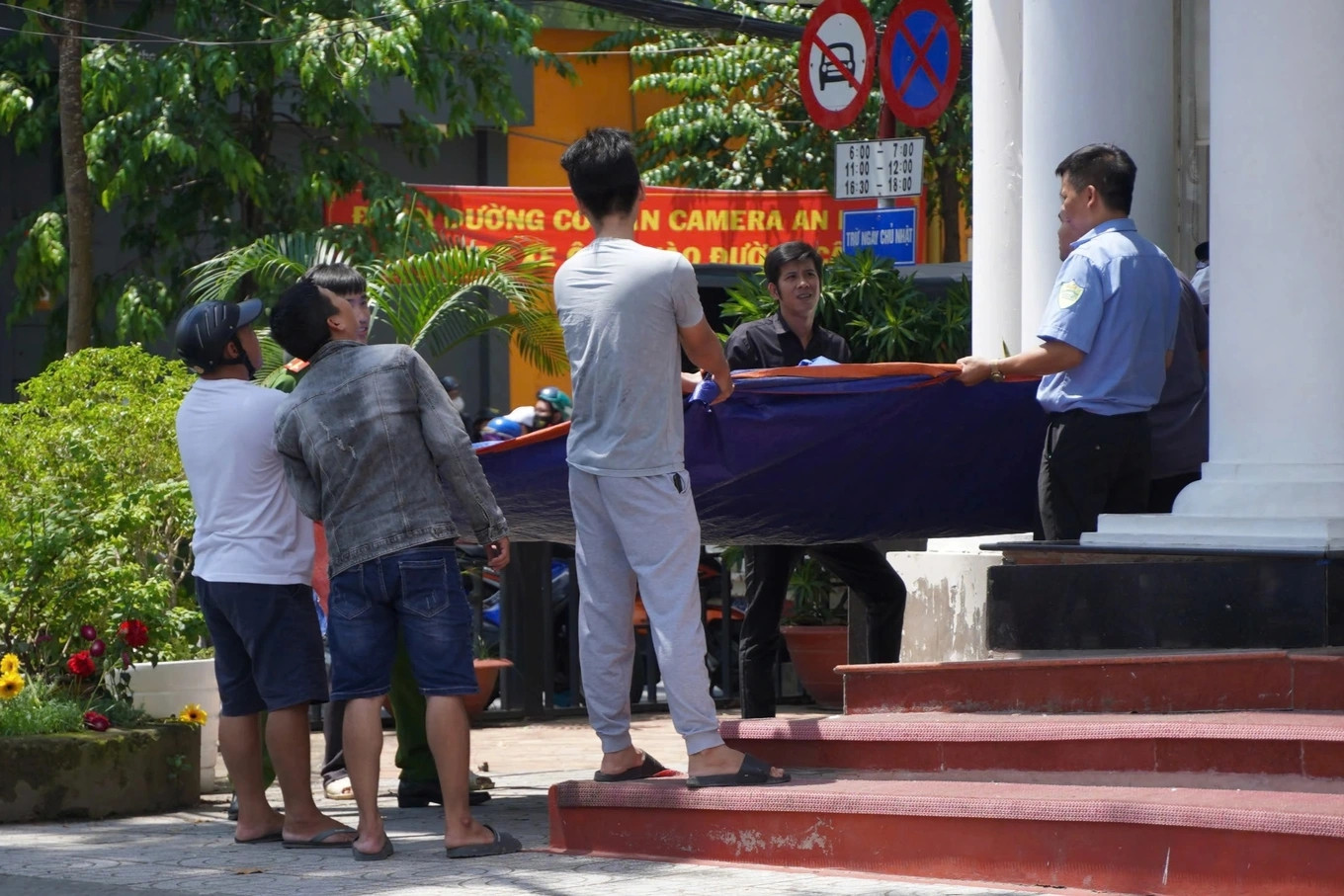 Lực lượng chức năng cùng người dân cầm tấm đệm được bơm đầy hơi bố trí dưới mặt đất đề phòng thanh niên này nhảy xuống. (Ảnh: Dân trí) Lực lượng chức năng cùng người dân cầm tấm đệm được bơm đầy hơi bố trí dưới mặt đất đề phòng thanh niên này nhảy xuống. (Ảnh: Dân trí)