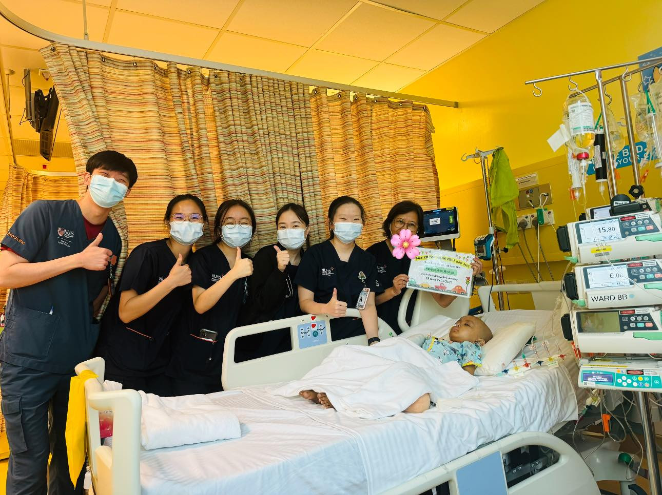 Bé Bắp chụp ảnh cùng các y bác sĩ của bệnh viện ở Singapore trong thời gian điều trị.