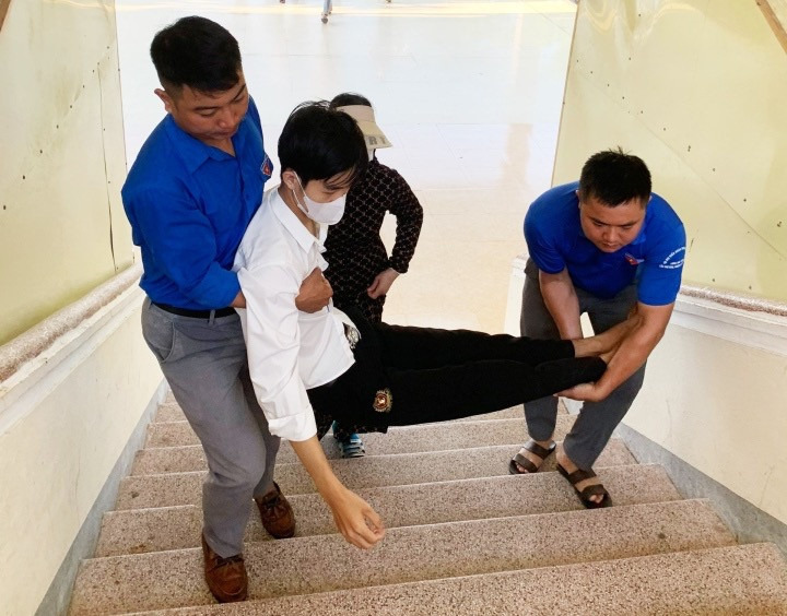 TNV bế nam sinh bị gãy chân vào phòng thi. (Ảnh: Tỉnh Đoàn Hà Tĩnh)