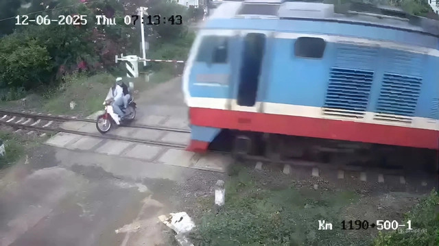 Hình ảnh tại thời điểm xe máy do ông V. điều khiển bị tàu hỏa tông. (Ảnh: Cắt từ clip) Hình ảnh tại thời điểm xe máy do ông V. điều khiển bị tàu hỏa tông. (Ảnh: Cắt từ clip)