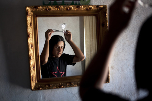 Tylor ngắm mình trong gương và tự đeo chiếc vương miện bằng giấy mà 