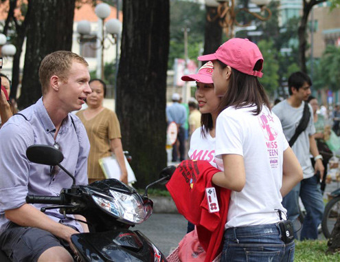 Một nhóm thí sinh đang quảng cáo sản phẩm với khách Tây