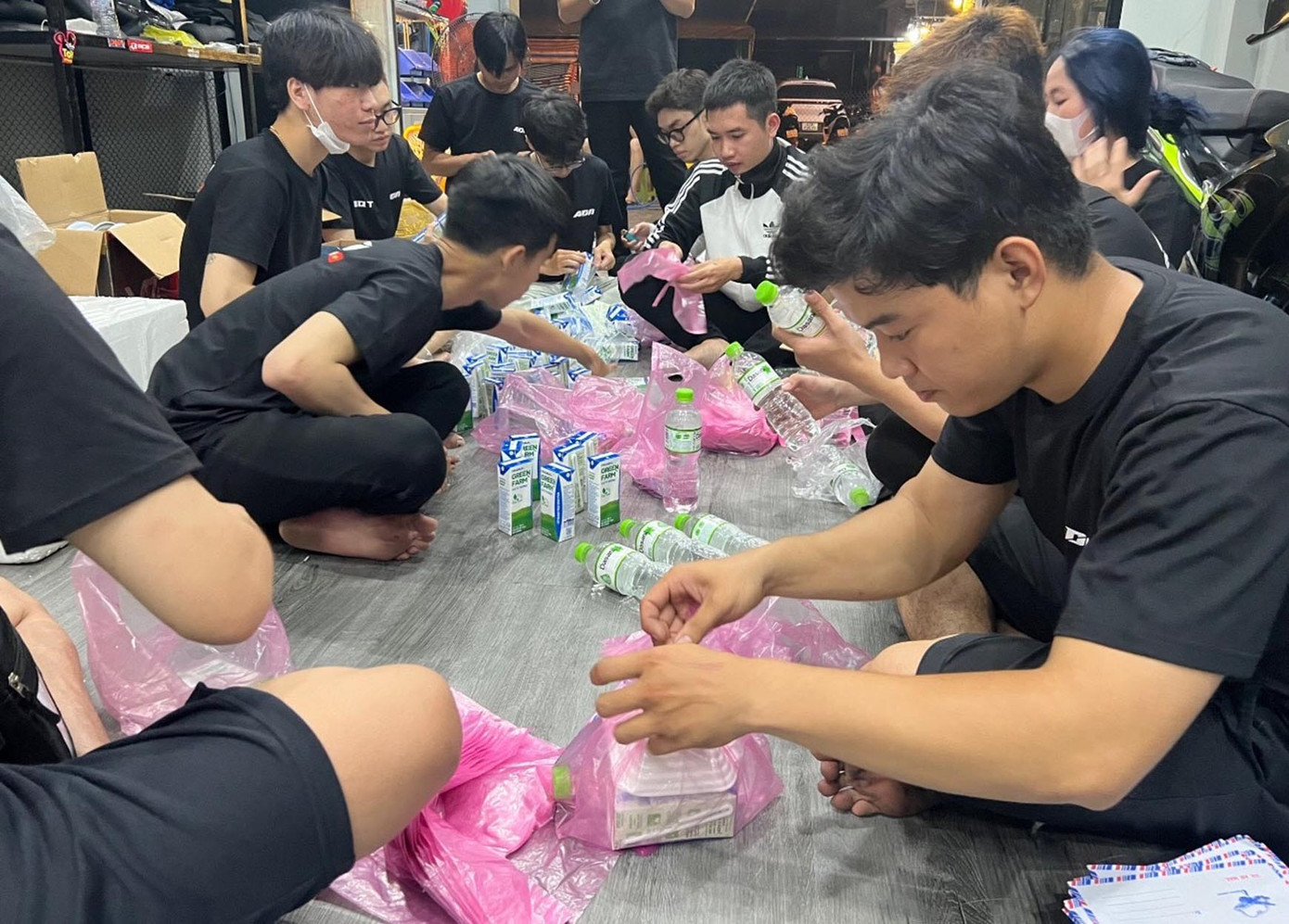 Anh Nguyễn Hữu Tài - Trưởng nhóm ADN (áo đen hàng đầu bên phải) cho biết, hiện anh đang kinh doanh mảng phụ tùng đồ chơi xe. “Mỗi dịp đầu tháng anh em trong nhóm quyên góp tiền, quà và cùng nhau chuẩn bị sắp xếp đóng gói tại tiệm của mình, sau đó sẽ đi dọc các tuyến phố để tặng quà cho các cô chú”. Ảnh: NVCC