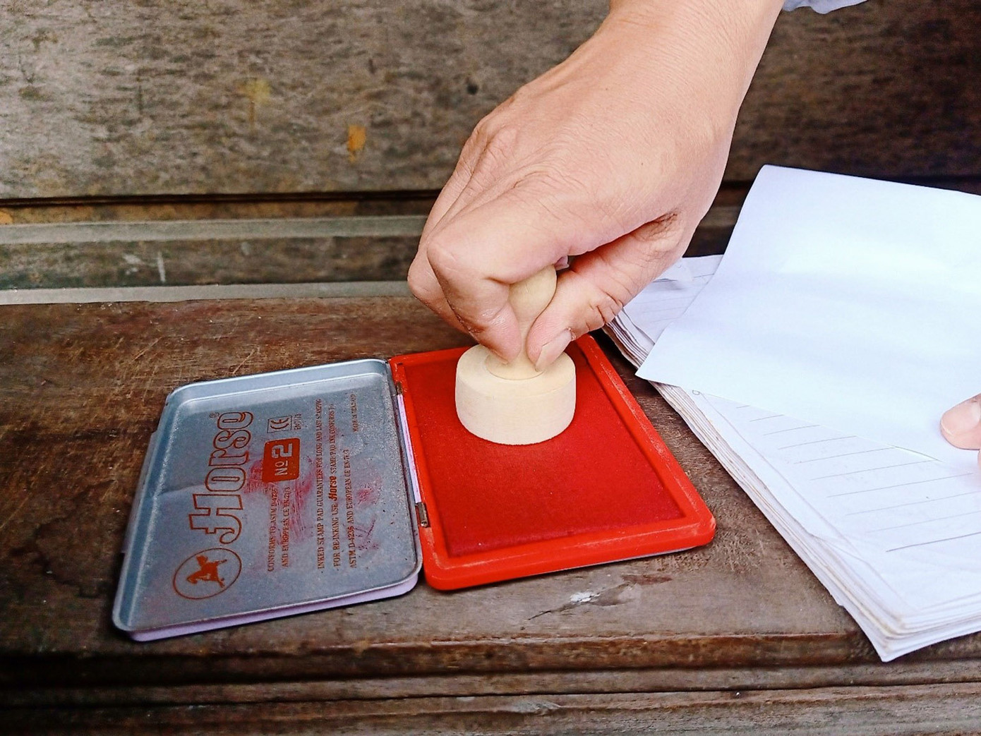 Khi làm xong, khách về muốn in loại mực nào cũng được, còn anh thường sử dụng loại mực dấu đỏ thông thường. (Ảnh: Hằng Hương)