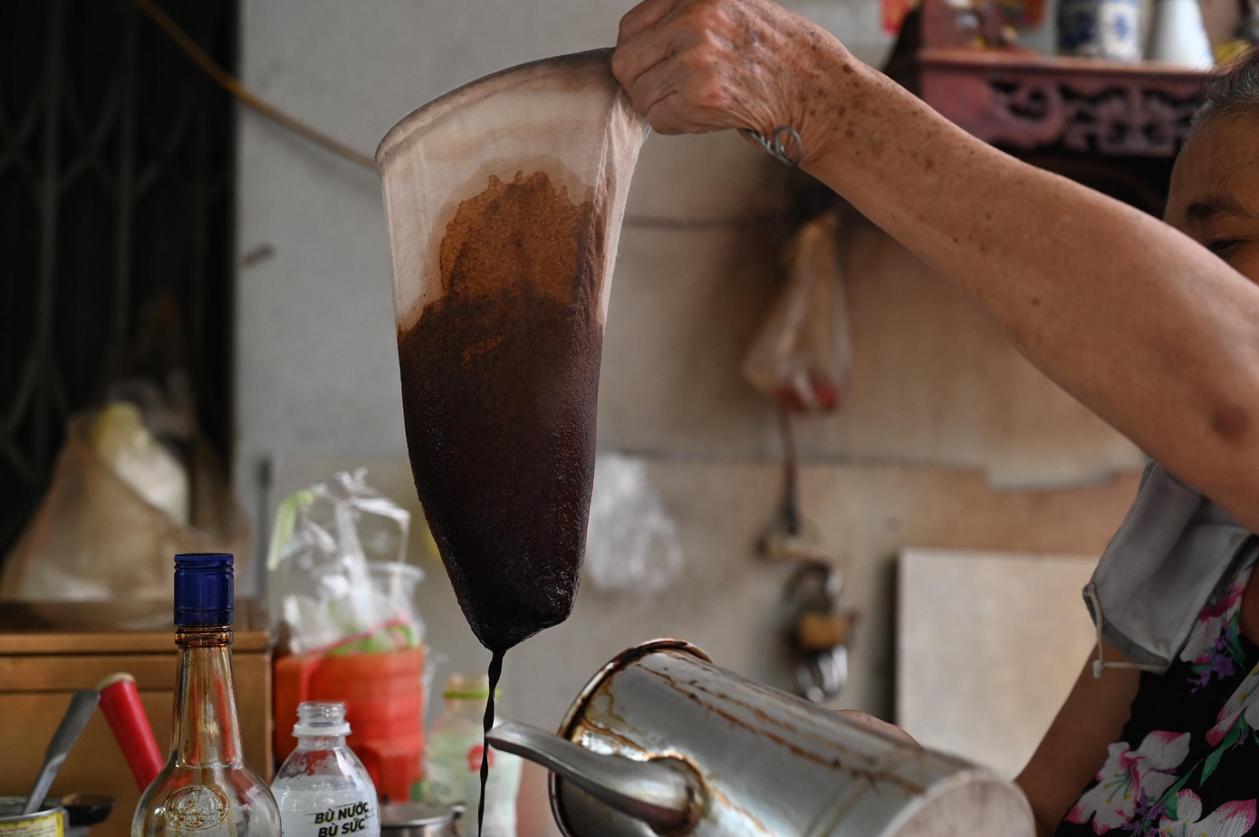 Bà Liên cởi mở chia sẻ về cách làm ra một ly cà phê vợt đậm vị. Nấu cà phê trong bình inox sau đó bỏ xác cà phê vào cái túi bằng vải gọi là cái vợt... - ảnh Huỳnh Như