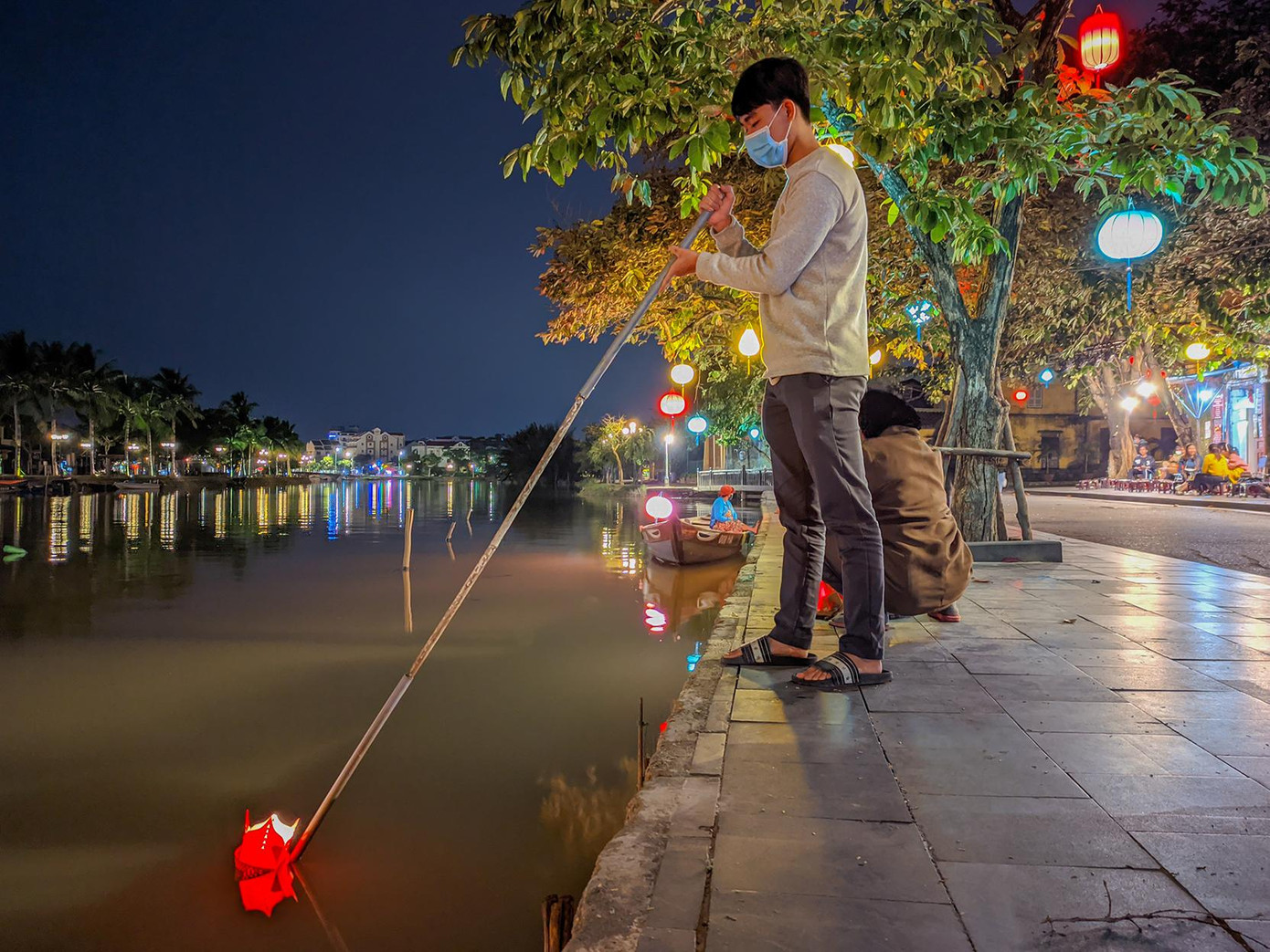 Bạn trẻ Nguyễn Văn Thìn (21 tuổi, quê ở Quảng Nam) trải nghiệm thả đèn hoa đăng bên bờ sông Hoài. “Dịch bệnh ảnh hưởng rất nhiều đến việc học tập của mình, nhưng cũng giúp mình nhận ra nhiều giá trị khi phải sống chậm hơn một nhịp. Đến đây thả đèn hoa đăng một phần là để trải nghiệm và mình cũng cầu mong đại dịch qua mau để trở lại cuộc sống bình thường như trước kia”, Thìn chia sẻ.