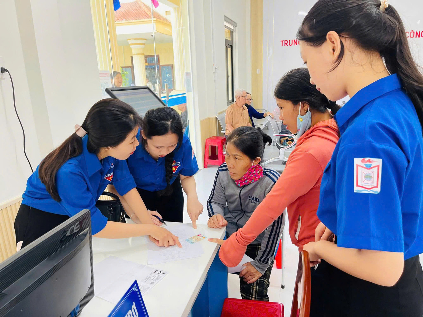 Các đội hình thanh niên tình nguyện phối hợp với lực lượng chức năng hỗ trợ người dân sử dụng các dịch vụ công trực tuyến. Ảnh: Nguyễn Ngọc