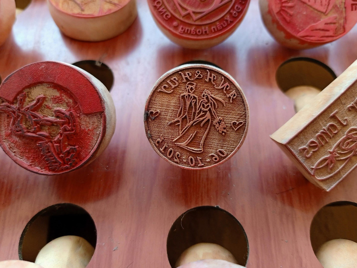 Chỉ cần một bức ảnh chân dung của khách, trong chốc lát anh đã “truyền thần” lên mặt con dấu gỗ nhỏ xinh, giống hệt với người bên ngoài. Du khách thích thú về nước mang theo món quà kỷ niệm độc lạ, có thể in ra tặng người thân, bạn bè. (Ảnh: Hằng Hương)