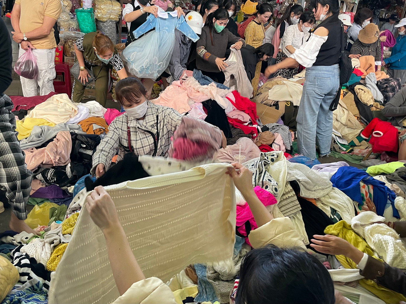 Quần áo được đổ trên những tấm bạt và chất thành đống. Giá thành dao động từ 10.000 – 50.000 đồng/cái nhưng vẫn có thể đáp ứng được nhu cầu, sở thích của bản thân, sắm sửa đồ diện Tết với chi phí rẻ. Ảnh: Trúc Linh Quần áo được đổ trên những tấm bạt và chất thành đống. Giá thành dao động từ 10.000 – 50.000 đồng/cái nhưng vẫn có thể đáp ứng được nhu cầu, sở thích của bản thân, sắm sửa đồ diện Tết với chi phí rẻ. Ảnh: Trúc Linh