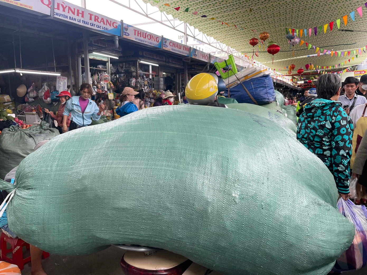 Các tiểu thương bận rộn chuyển những bao tải quần áo nặng từ 60 đến 80 kg vào khu vực đồ si, chuẩn bị cho việc bày bán khi giờ đến. Ảnh: Trúc Linh Các tiểu thương bận rộn chuyển những bao tải quần áo nặng từ 60 đến 80 kg vào khu vực đồ si, chuẩn bị cho việc bày bán khi giờ đến. Ảnh: Trúc Linh