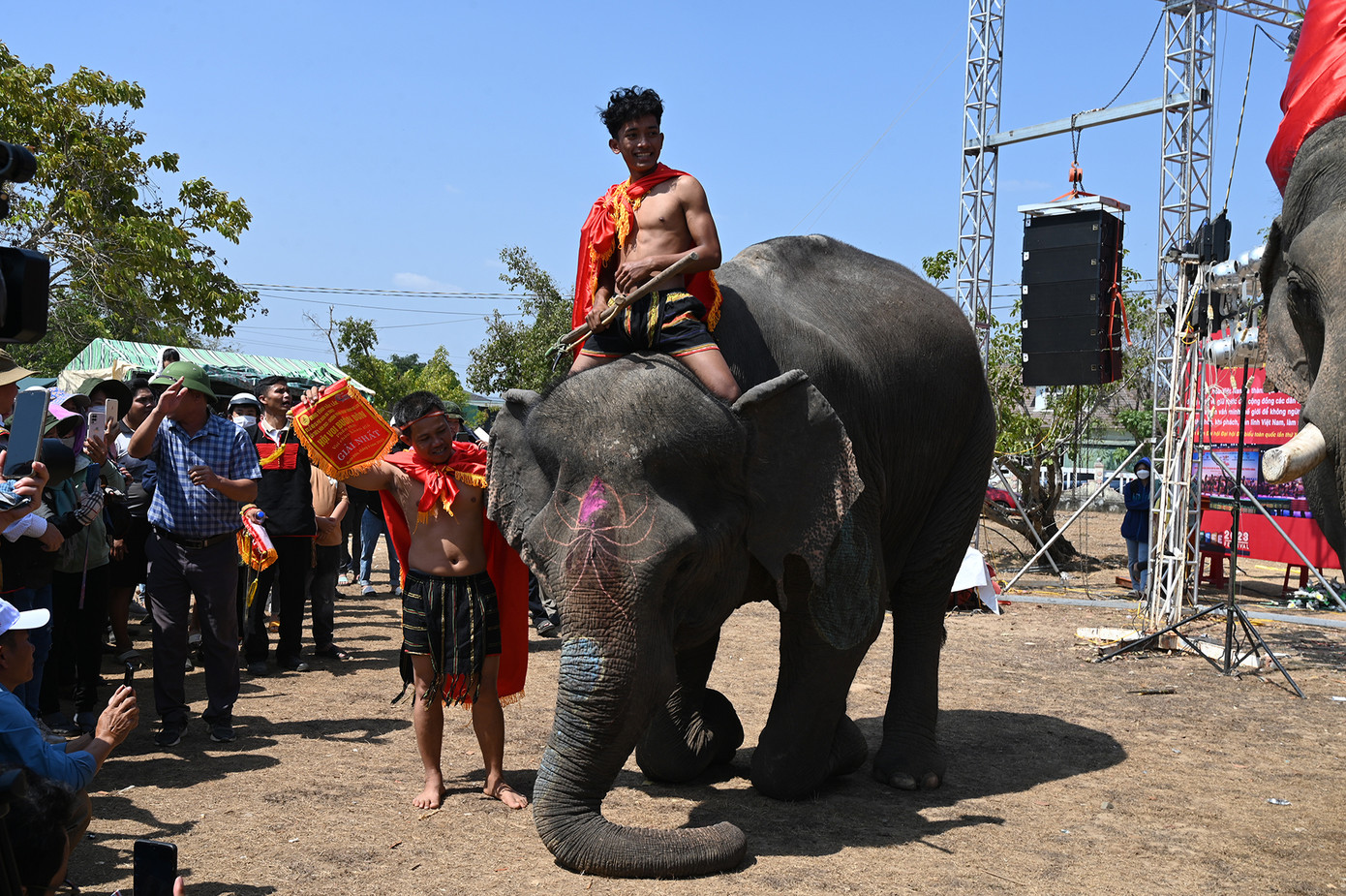 Y Quang Bya một nài voi trẻ tuổi với chú voi đạt giải nhất lễ hội năm nay, được chính cậu trang điểm rực rỡ đang thi chào khán giả (Ảnh: Huỳnh Như) Y Quang Bya một nài voi trẻ tuổi với chú voi đạt giải nhất lễ hội năm nay, được chính cậu trang điểm rực rỡ đang thi chào khán giả (Ảnh: Huỳnh Như)