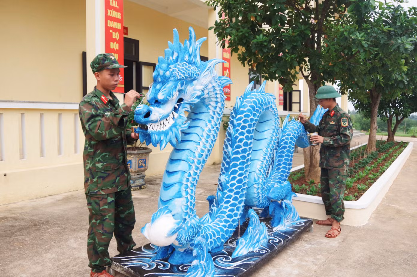 Tổ gồm 3 đồng chí: Trung sĩ Cao Quang Long Vũ, Tiểu đội trưởng Tiểu đội 2, Trung đội 7 - đảm nhiệm vẽ và thiết kế mô hình, trang trí; Binh nhất Nguyễn Quốc Huy, chiến sĩ Tiểu đội 2, Trung đội 7 - đảm nhiệm làm hồ, đắp xi măng; Binh nhất Trương Quốc Đạt, chiến sĩ Tiểu đội 5, Trung đội 8 - trang trí, sơn màu. Ảnh: Ngọc Tú Tổ gồm 3 đồng chí: Trung sĩ Cao Quang Long Vũ, Tiểu đội trưởng Tiểu đội 2, Trung đội 7 - đảm nhiệm vẽ và thiết kế mô hình, trang trí; Binh nhất Nguyễn Quốc Huy, chiến sĩ Tiểu đội 2, Trung đội 7 - đảm nhiệm làm hồ, đắp xi măng; Binh nhất Trương Quốc Đạt, chiến sĩ Tiểu đội 5, Trung đội 8 - trang trí, sơn màu. Ảnh: Ngọc Tú