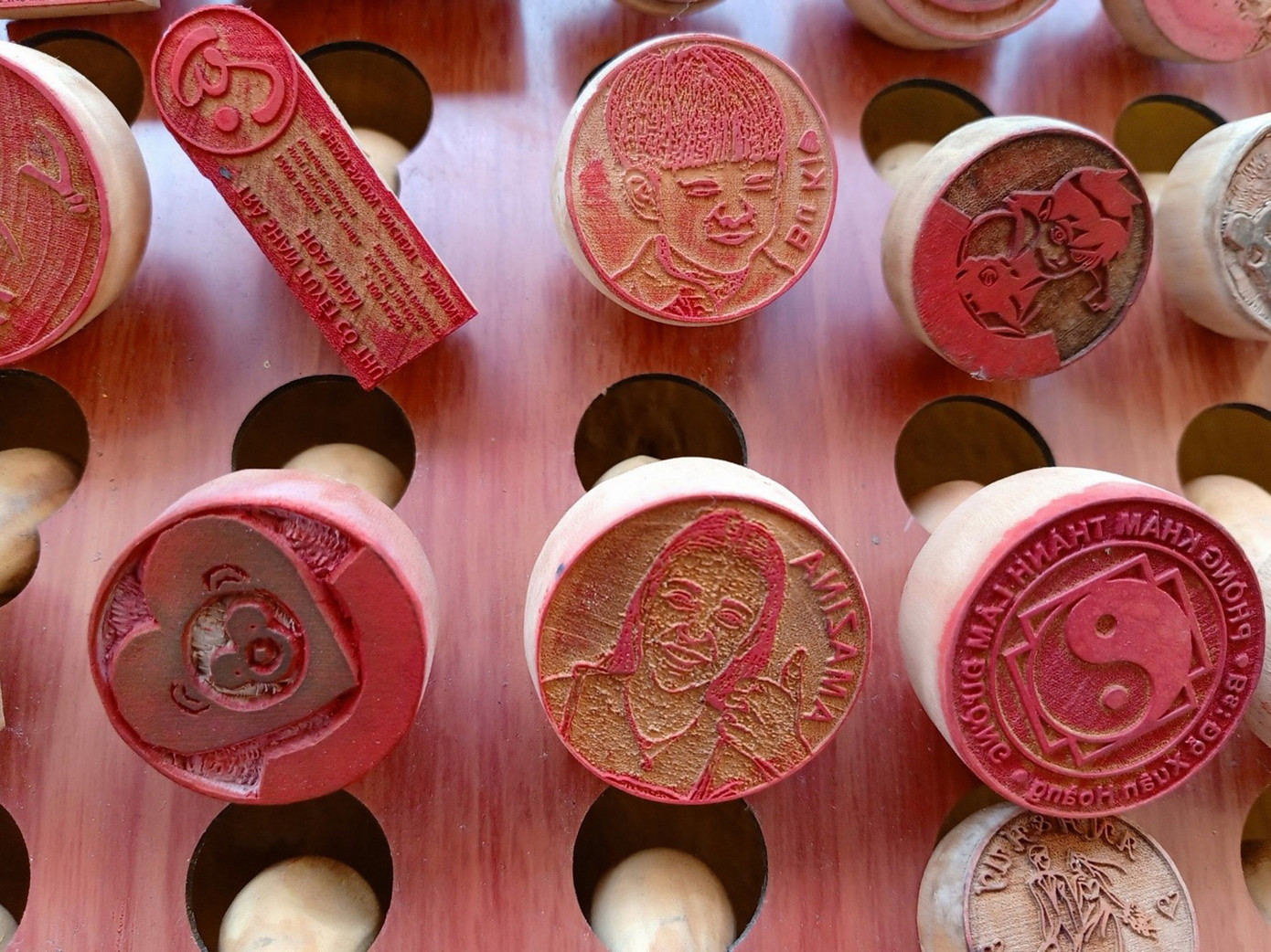 Chỉ cần một bức ảnh chân dung của khách, trong chốc lát anh đã “truyền thần” lên mặt con dấu gỗ nhỏ xinh, giống hệt với người bên ngoài. Du khách thích thú về nước mang theo món quà kỷ niệm độc lạ, có thể in ra tặng người thân, bạn bè. (Ảnh: Hằng Hương)