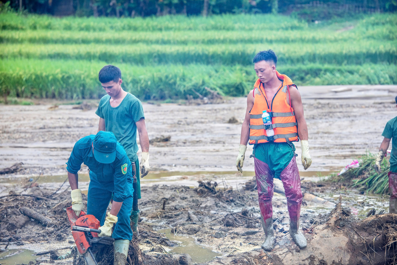 Để dọn ruộng, các chiến sĩ phải mang ủng cao tới sát bẹn, vì bùn vẫn ngập sâu. Ảnh: Văn Chương Để dọn ruộng, các chiến sĩ phải mang ủng cao tới sát bẹn, vì bùn vẫn ngập sâu. Ảnh: Văn Chương