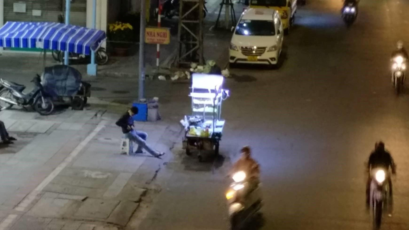 Trên đường Điện Biên Phủ, một người bán hàng rong ngồi co ro đợi khách. Trên đường Điện Biên Phủ, một người bán hàng rong ngồi co ro đợi khách.