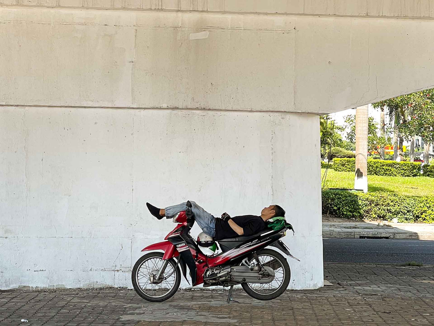 Họ lấy xe làm giường, áo làm gối, gió nóng làm quạt để tranh thủ chợp mắt nghỉ trưa lấy sức trong lúc chờ khách. (Ảnh: Thanh An)