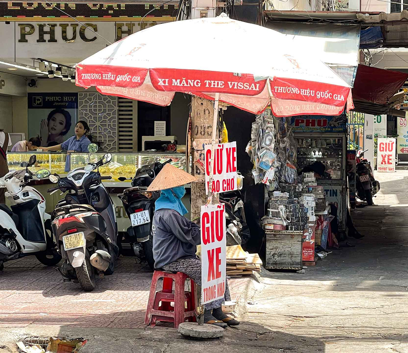 Làm nghề trông xe ở chợ Cồn, cô Thị Hòa (57 tuổi, trú quận Thanh Khê, TP. Đà Nẵng) cho biết: “Dù nắng hay mưa, chúng tôi vẫn phải lao động. Vào những hôm nhiệt độ cao, tôi dễ bị say nắng. Vì vậy tôi thường xuyên bù nước và mang theo khăn ướt để giải nhiệt”. (Ảnh: Thanh An)