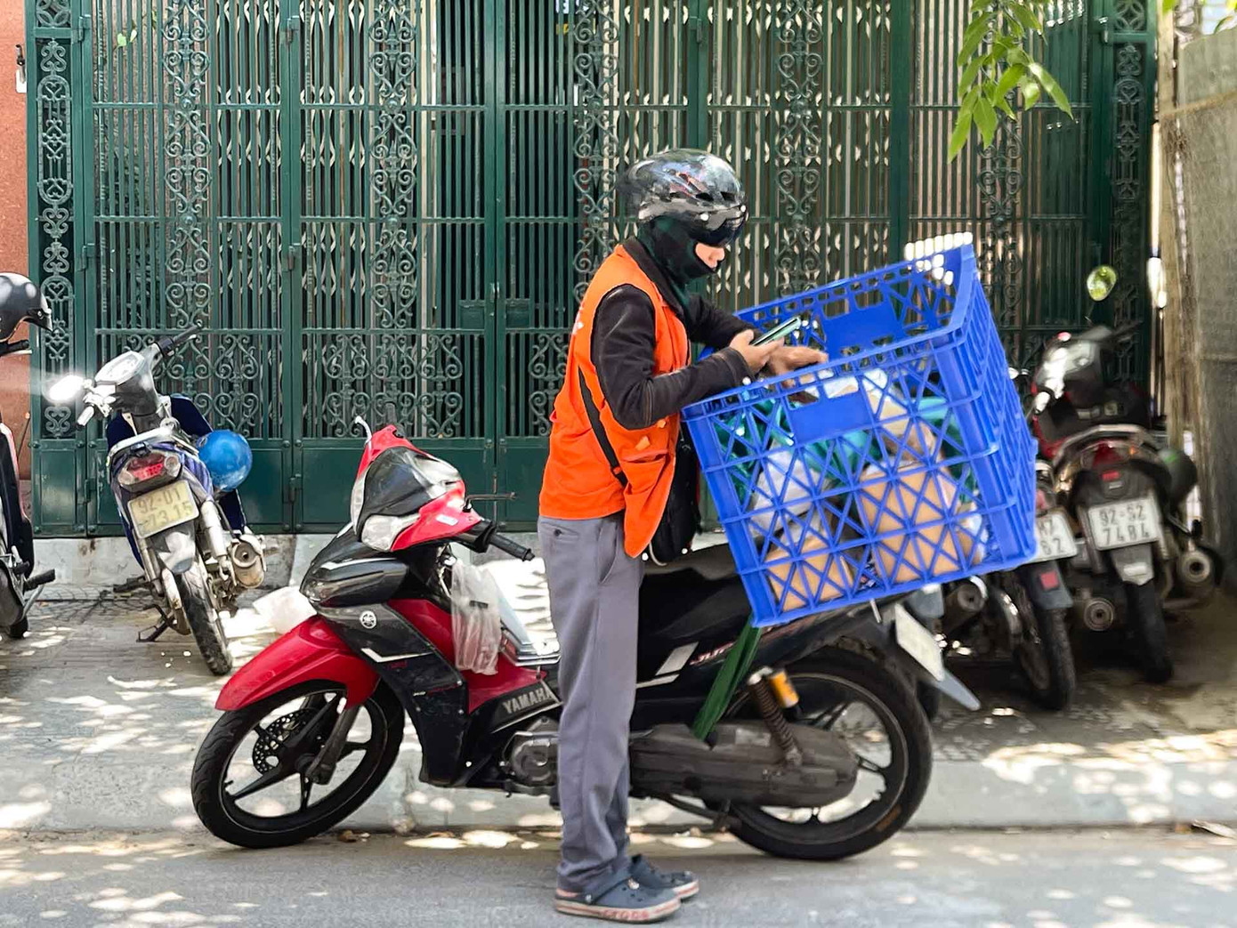 Người giao hàng và xe ôm công nghệ trang bị đầy đủ quần áo, găng tay, khẩu trang, mũ... để hạn chế tiếp xúc với ánh nắng. Anh Xuân Hoàng (25 tuổi, trú quận Liên Chiểu) chia sẻ: “Nếu chịu khó, nhất là giao vào khung giờ cao điểm thì thu nhập cũng khá, một phần là nhờ khách thương mà hỗ trợ thêm một chút”. (Ảnh: Thanh An)