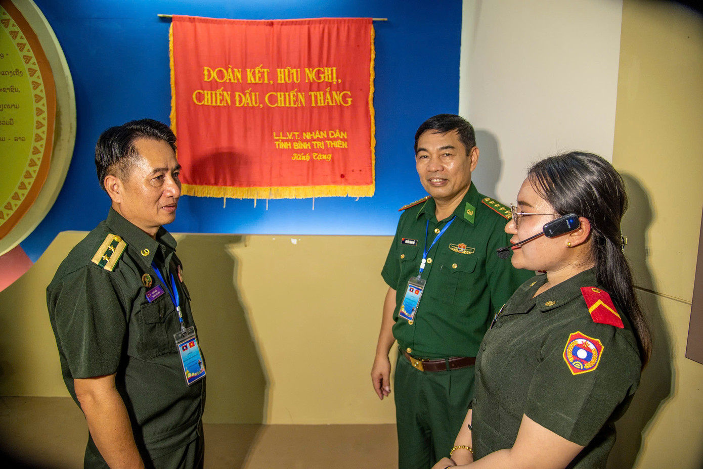 Hướng dẫn viên của Bảo tàng truyền thống liên minh chiến đấu Lào - Việt Nam thuyết trình về hiện vật với Thượng tá Sắc-lít Phị-phít, Phó Cục trưởng Cục Bộ đội Biên phòng (Bộ tổng Tham mưu Quân đội Nhân dân Lào) và Đại tá Nguyễn Thanh Hải, Phó Chủ nhiệm Chính trị Bộ đội Biên phòng Việt Nam. Ảnh: Văn Chương