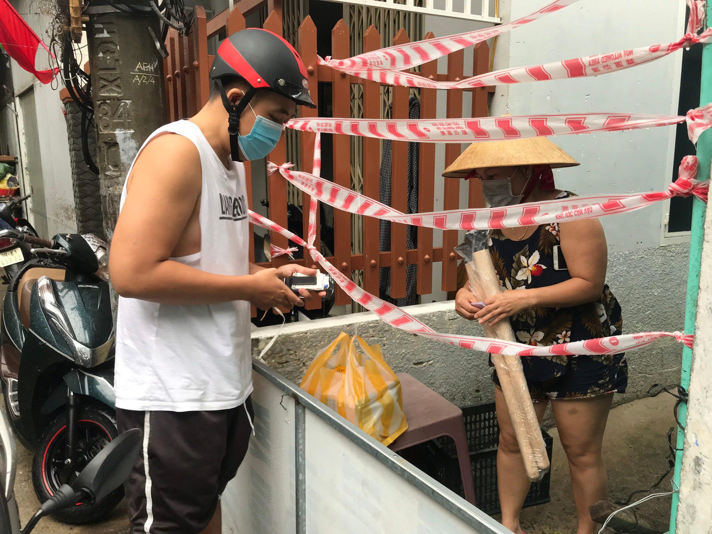 Giữa lúc gần như toàn bộ TP Đà Nẵng nhộn nhịp trở lại từ khoảng 10 ngày nay, thì bên trong các điểm còn bị phong tỏa cứng vì dịch COVID-19 mọi sinh hoạt vẫn phải tiếp tế từ bên ngoài - ảnh Th.L