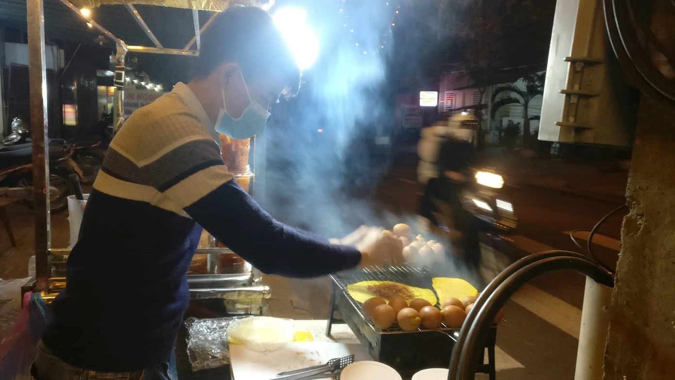 Người bán hàng mặc áo khá mỏng, nhưng nhờ hơi ấm từ bếp lửa nên vẫn đủ chống chọi với cái rét. Người bán hàng mặc áo khá mỏng, nhưng nhờ hơi ấm từ bếp lửa nên vẫn đủ chống chọi với cái rét.