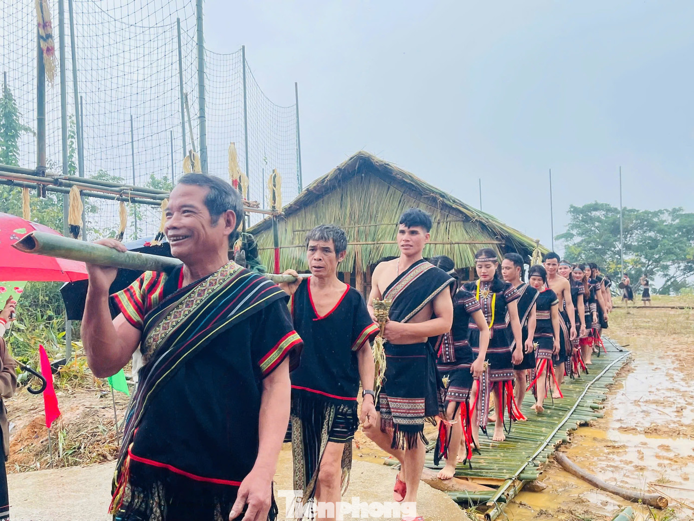 Bà con theo sau cùng khiêng các lễ vật như con heo, con gà để dâng lên thần trong lễ cúng.