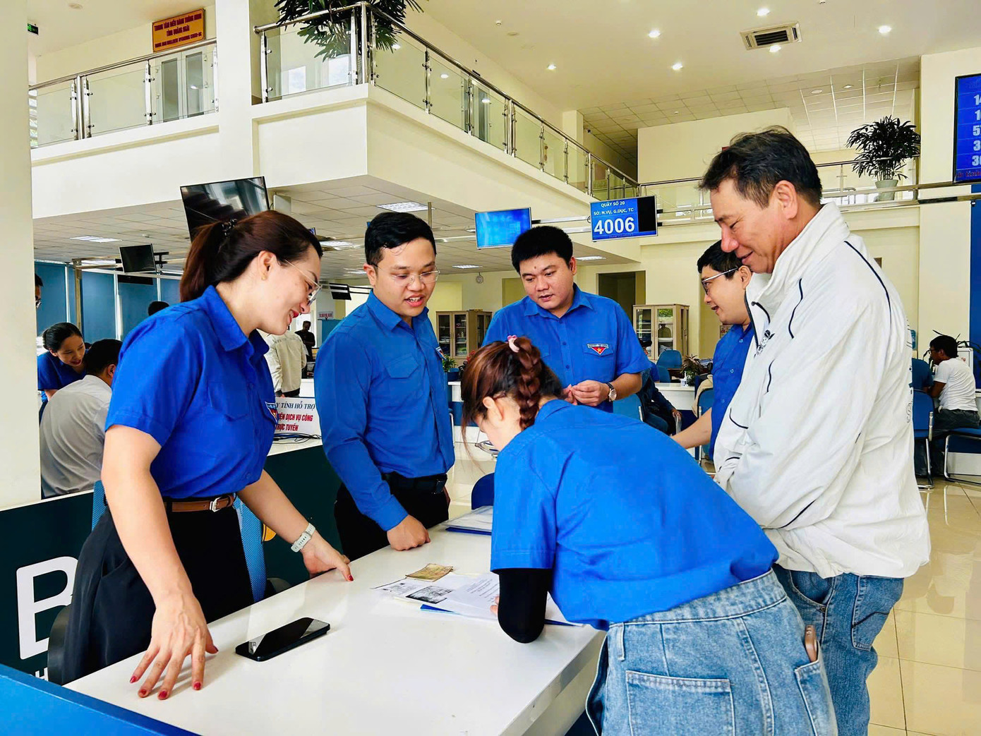 Các đội hình thanh niên tình nguyện phối hợp với lực lượng chức năng hỗ trợ người dân sử dụng các dịch vụ công trực tuyến. Ảnh: Nguyễn Ngọc