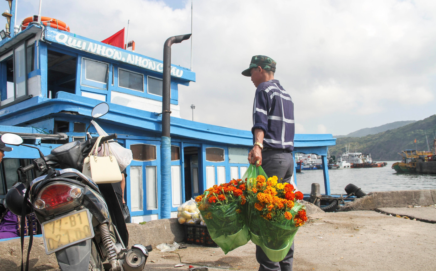 Những chậu hoa vạn thọ được người dân mua đem lên đò mang ra xã đảo Nhơn Châu. (Ảnh: Trương Định)