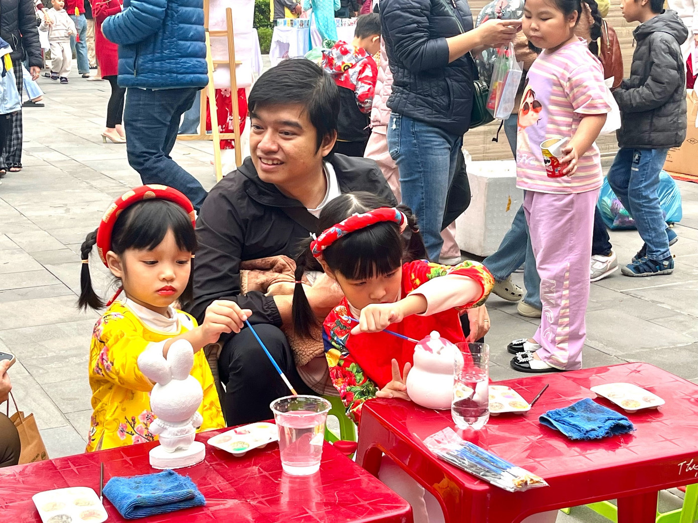 Nhiều bạn nhỏ được bố mẹ dẫn đi chơi chợ Tết, được tô tượng, xem nặn tò he... Ảnh: Lệ Thủy. Nhiều bạn nhỏ được bố mẹ dẫn đi chơi chợ Tết, được tô tượng, xem nặn tò he... Ảnh: Lệ Thủy.