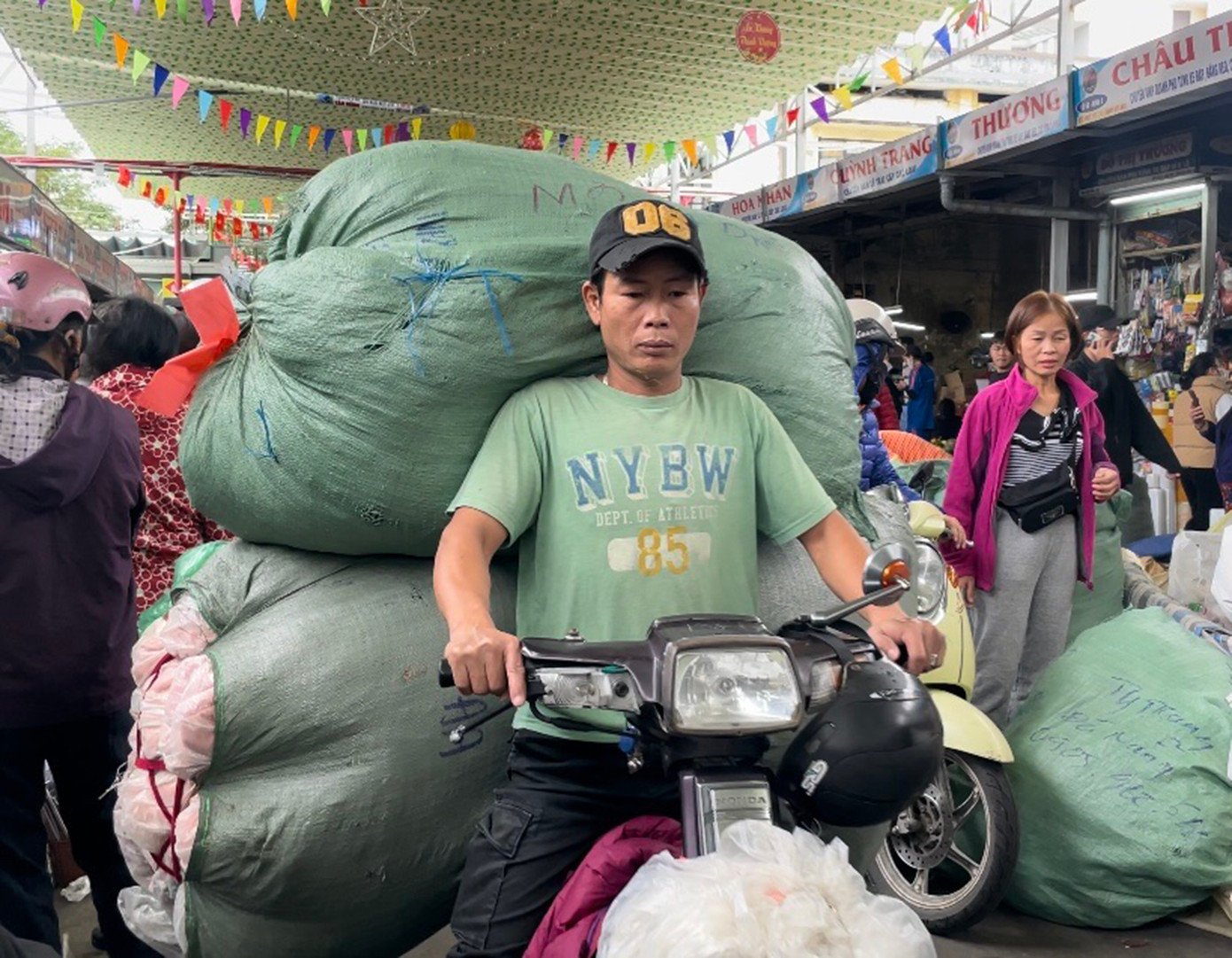 Các tiểu thương bận rộn chuyển những bao tải quần áo nặng từ 60 đến 80 kg vào khu vực đồ si, chuẩn bị cho việc bày bán khi giờ đến. Ảnh: Trúc Linh Các tiểu thương bận rộn chuyển những bao tải quần áo nặng từ 60 đến 80 kg vào khu vực đồ si, chuẩn bị cho việc bày bán khi giờ đến. Ảnh: Trúc Linh