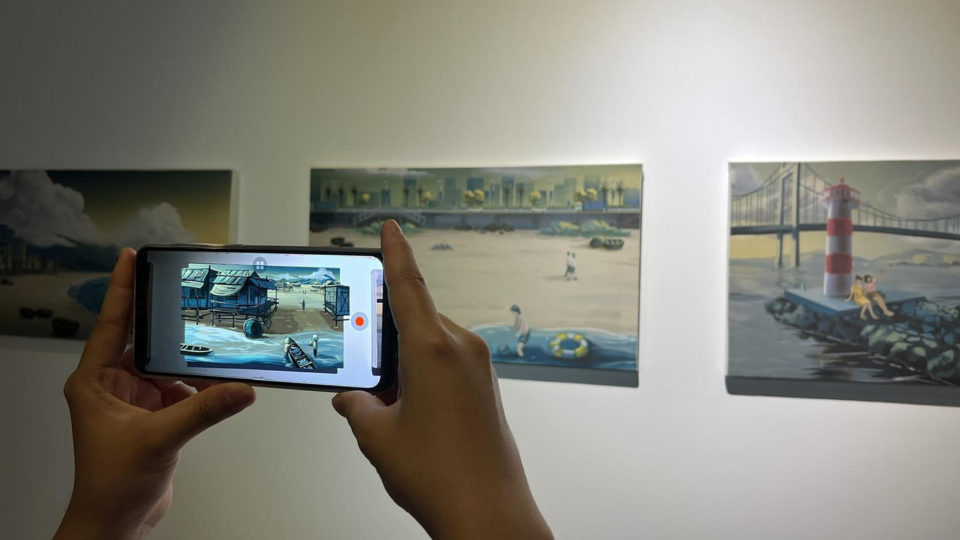 Chỉ với chiếc Smartphone, khách tham quan được xem bức tranh đó trong quá khứ, khác hẳn bức tranh nhìn bằng mắt thường (Ảnh: Bảo Quyên)