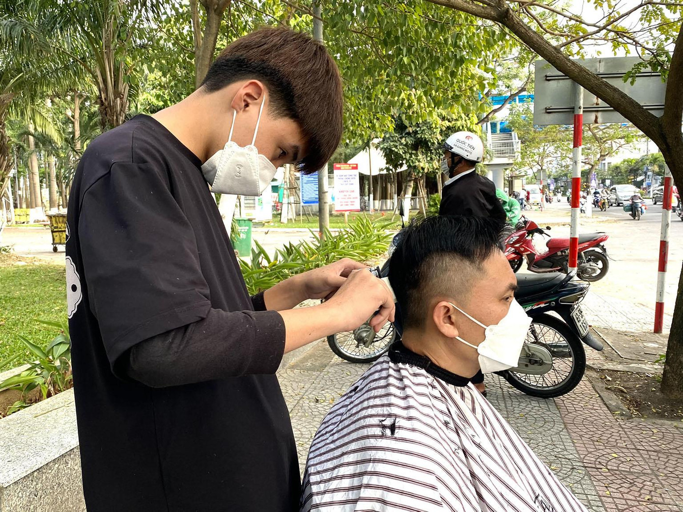 Ngồi chờ đến lượt cắt tóc, ông Nguyễn Văn Chí (59 tuổi, trú quận Hải Châu) – hành nghề chạy xe ôm cho biết từ khi dịch bệnh đến nay, lượng khách đi xe ôm giảm hẳn khiến cuộc sống của ông trở nên khó khăn. Ngày nào ế ẩm coi như không có tiền xăng, rồi còn phải lo chi phí cho gia đình. “Tui cũng hay ghé đây hớt. Hớt tóc ở chỗ này vì không mất tiền. Mấy anh em hớt ở đây rất đẹp và vui vẻ”, ông Chí vui vẻ nói. Ngoài những địa điểm cắt tóc miễn phí trên, anh Kỳ cùng nhóm của mình còn thường xuyên di chuyển đến những nơi có nhiều người qua lại. Đặc biệt là các khu có lao động hoặc dãy trọ công nhân để giúp đỡ được nhiều hơn những hoàn cảnh khó khăn khác. - Ảnh: Thái Lâm