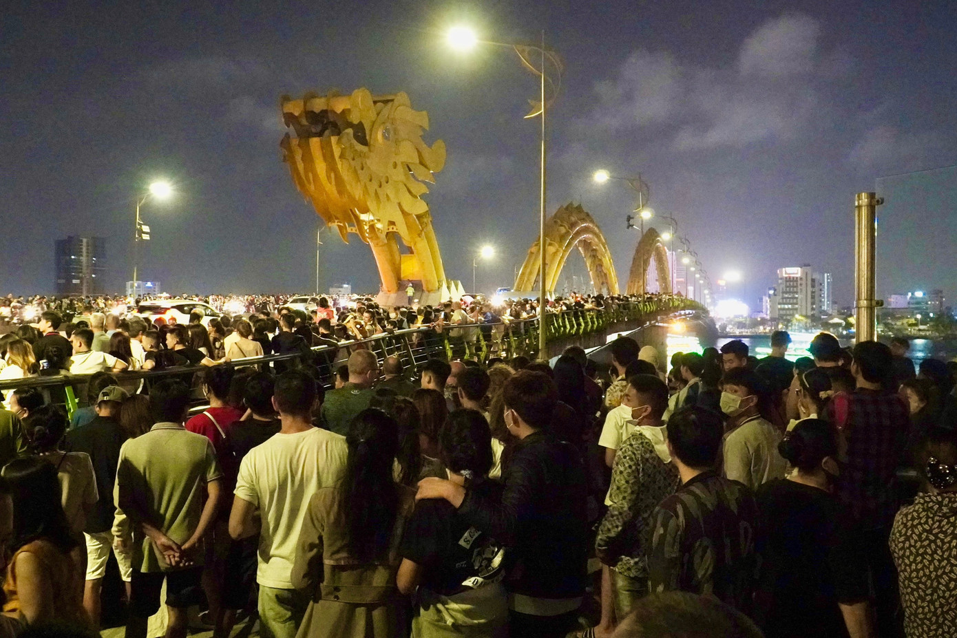 Là ngày cuối tuần, nên cầu Rồng vẫn là nơi thu hút đông đảo người dân và du khách, đúng vào thời khắc diễn ra Giờ trái đất. Ảnh: Thái Lâm