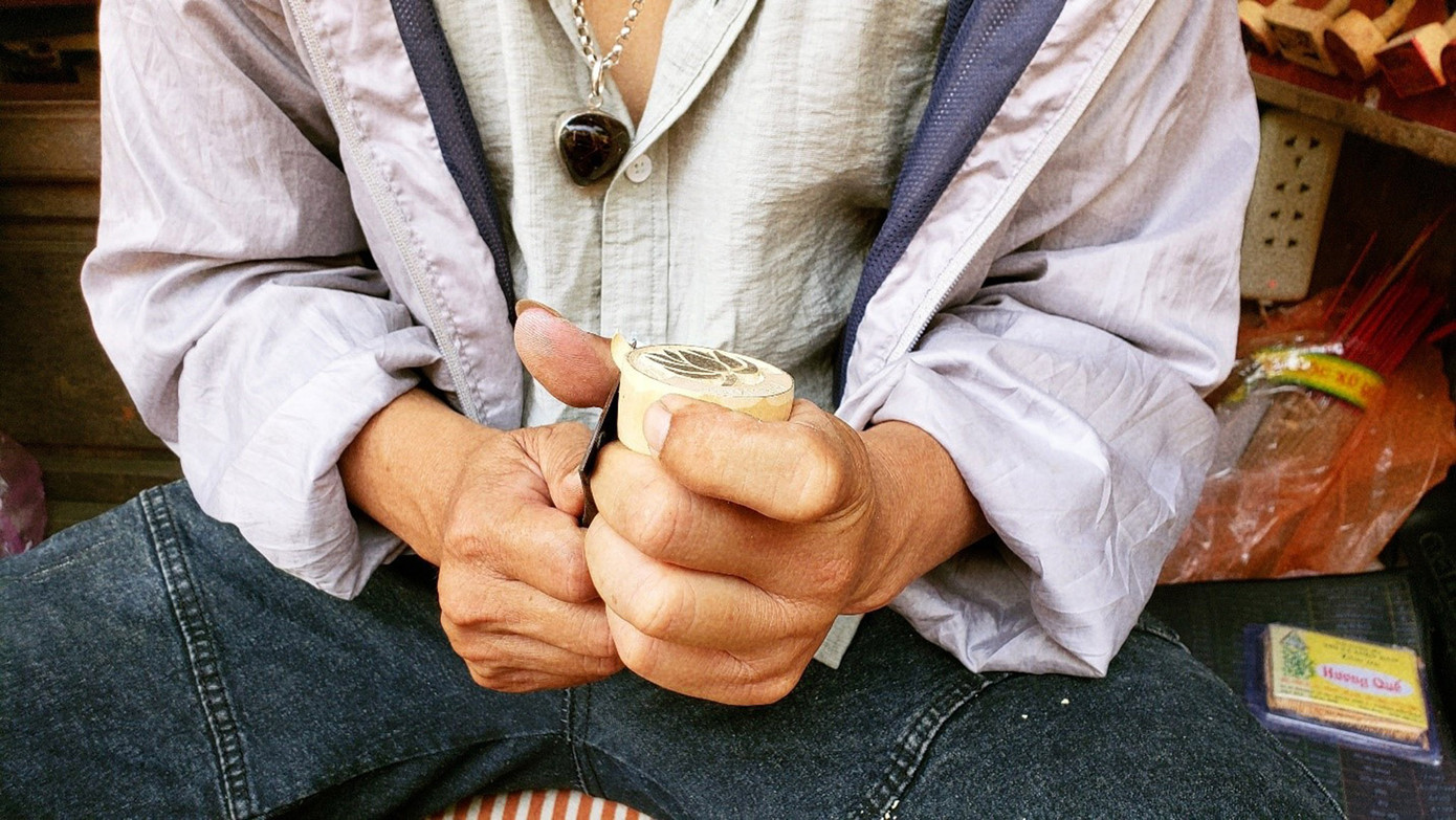 Sau khi sản phẩm đã thành hình, anh sẽ gọt những phần gỗ còn thừa xung quanh và tiếp tục mài nhẵn con dấu cho đến khi hoàn thiện. (Ảnh: Hằng Hương)