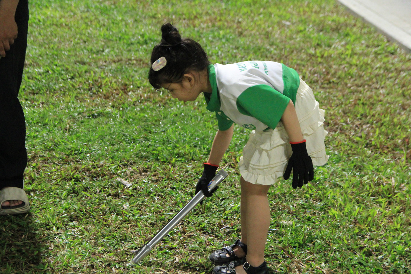 Bé Quỳnh Anh lớp 2 hào hứng tham gia nhặt rác cùng mọi người. Ảnh: Minh Hiền