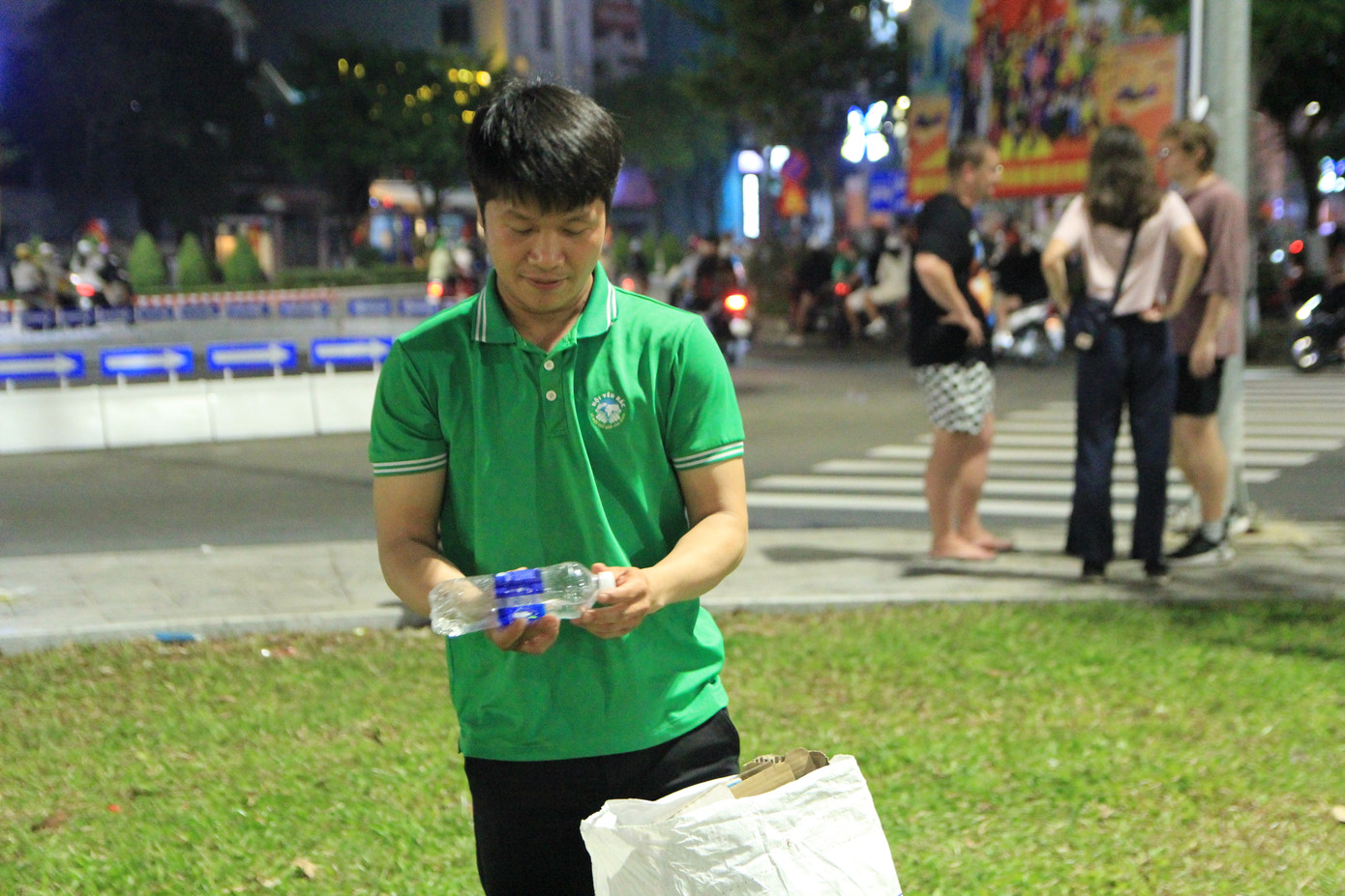 “Sau mỗi lần pháo hoa kết thúc các sân bãi thường rất nhiều rác. Nhóm mình đã quen với việc ở lại sau cùng, cùng nhau đi nhặt rác, gom gọn lại để các cô chú công nhân vệ sinh dễ thu dọn hơn. Đêm nay, có nhiều bạn tình nguyện viên nên chắc đến khoảng 12 giờ đêm là xong”, anh Trần Thanh Triều - thành viên đội tình nguyện, chia sẻ. Ảnh: Minh Hiền