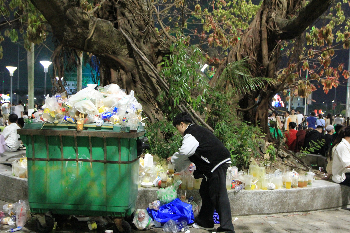Thùng rác sau đêm pháo hoa ở tình trạng quá tải và tràn ra ngoài. Ảnh: Minh Hiền