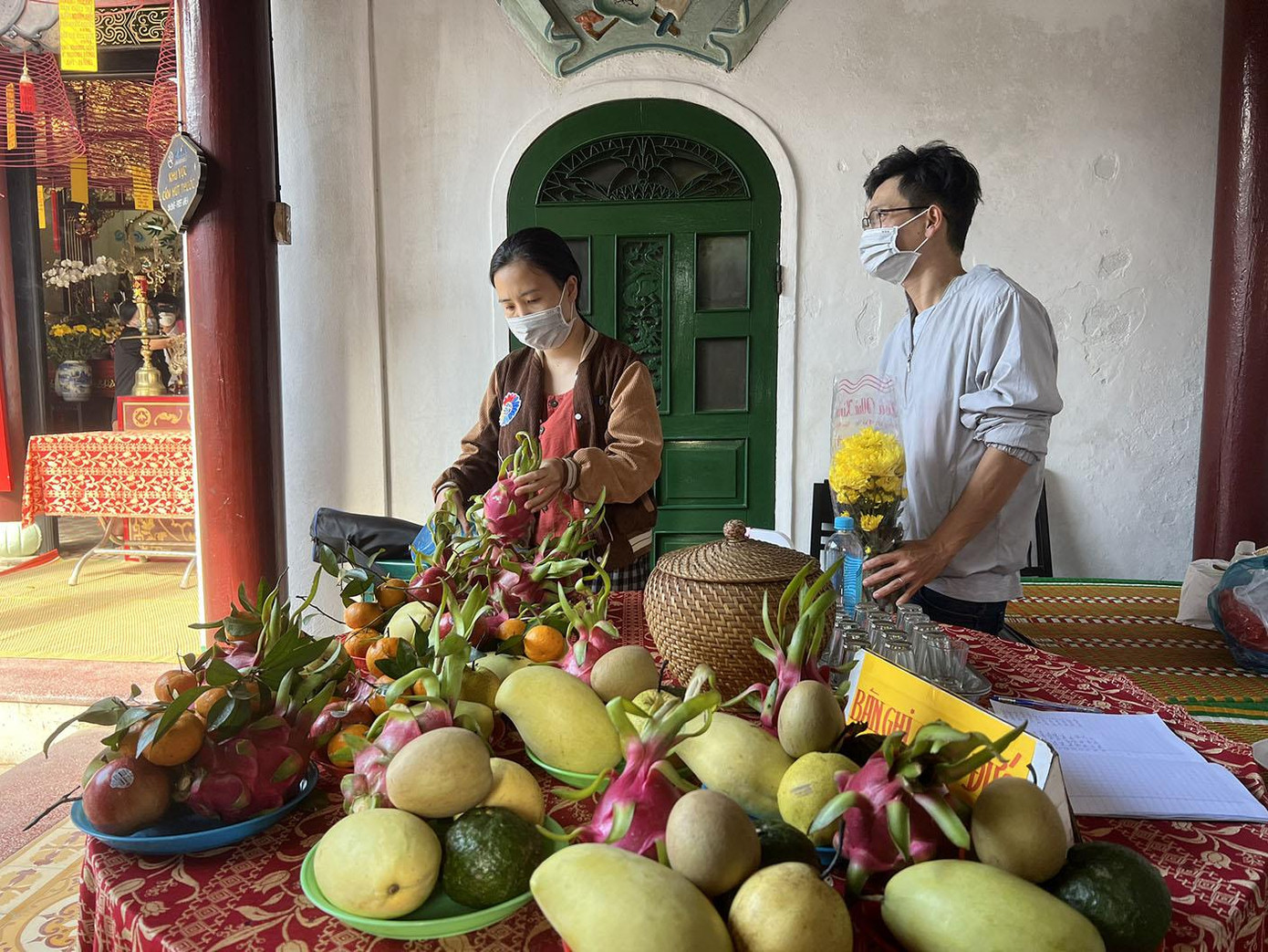 Vợ chồng đến cúng dâng trái cây và hoa để vía các Bà. - Ảnh: Bảo Châu.