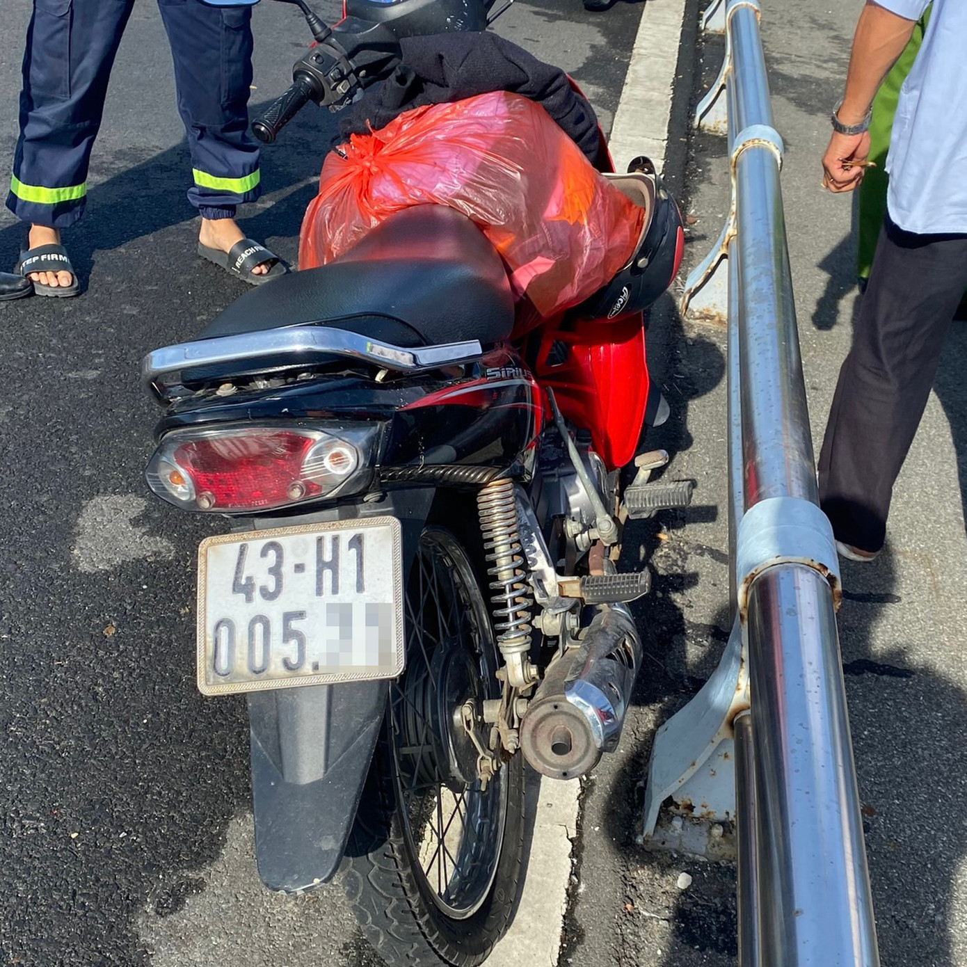 Chiếc xe máy cùng đồ đạc được nạn nhân để trên thành cầu Thuận Phước. Ảnh: CA