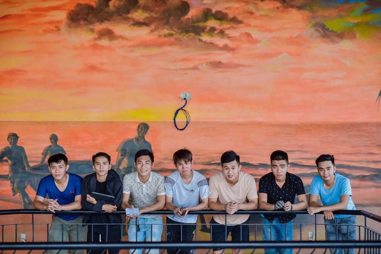 Sau đó chàng trai cùng những người bạn mở một studio vẽ tranh tường 2D, 3D chuyên nghiệp. Trong ảnh là Nguyễn Thành Trung (áo đen thứ hai từ trái sang) cùng những người cộng sự. Ảnh: NVCC.
