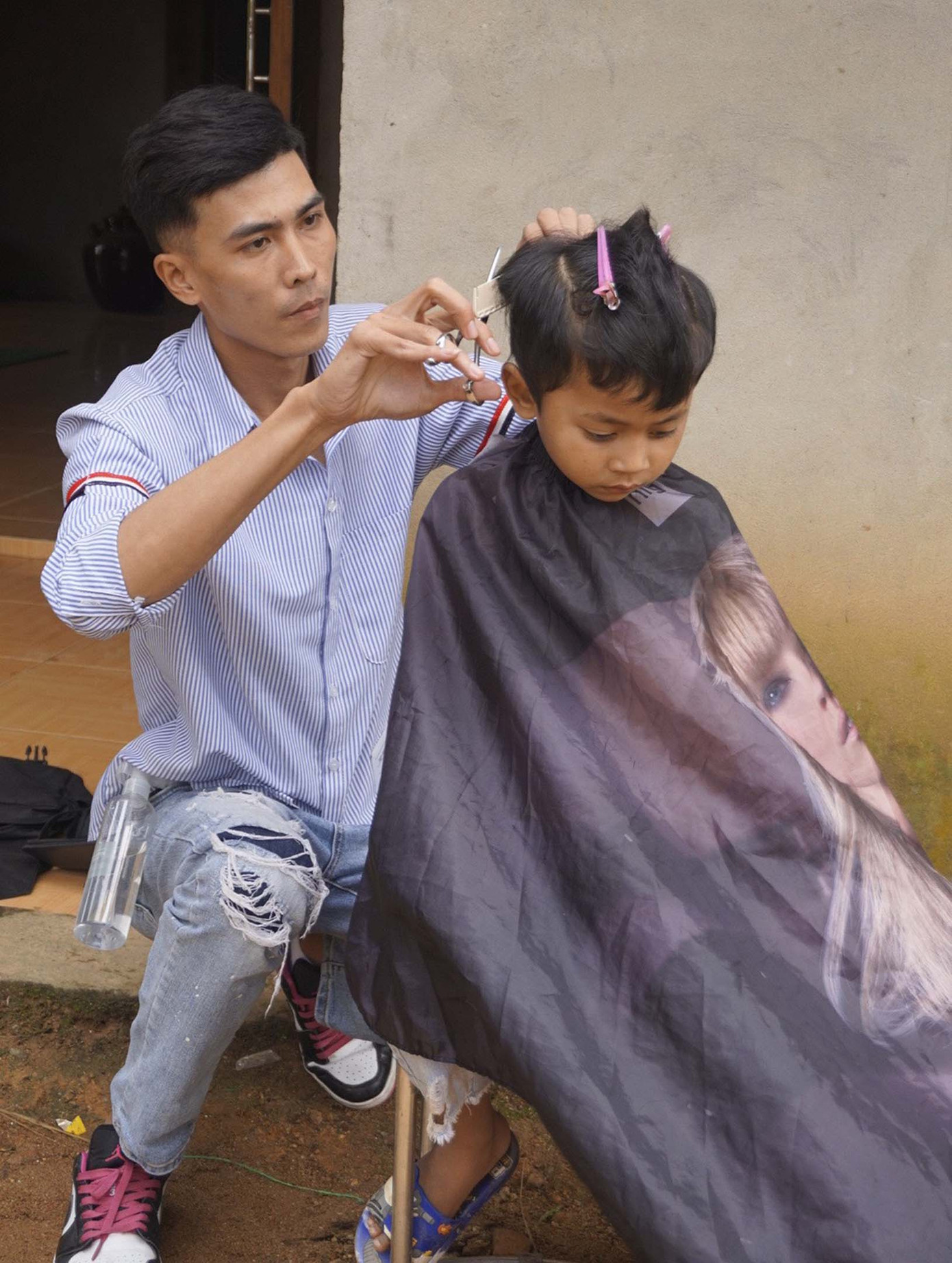 Các em nhỏ thôn R'cung vui với những đôi ủng mới và mái tóc mới