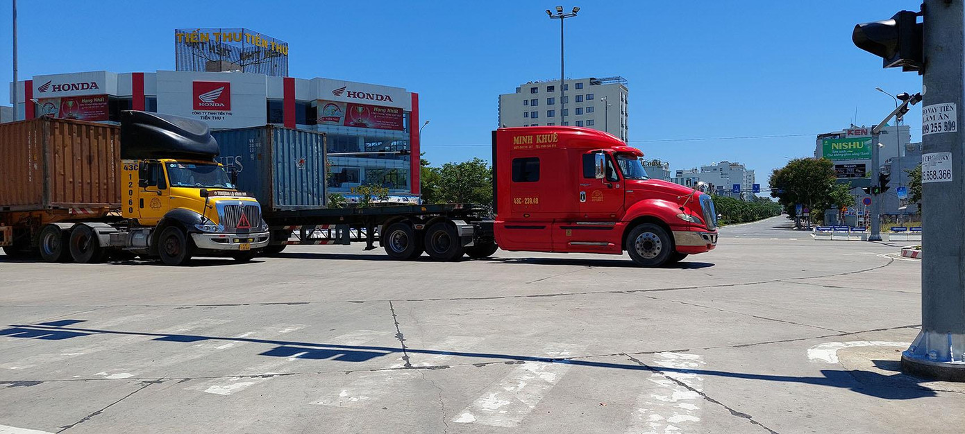 Các xe container chạy về hướng Cảng Đà Nẵng. Ông Trần Lê Tuấn, Tổng giám đốc Công ty CP Cảng Đà Nẵng cho biết: Tình hình đến hôm nay đã ổn định. Hôm qua (16/8) khi mới bắt đầu 7 ngày cả thành phố "đứng yên", lượt xe ra vào cảng có giảm. Một phần do các DN đã rút trước hàng để chủ động sản xuất trong mùa dịch, phần do một số chủ xe và lái xe chưa hoàn chỉnh giấy tờ thủ tục đi đường trong mùa dịch - ảnh Tr.T Các xe container chạy về hướng Cảng Đà Nẵng. Ông Trần Lê Tuấn, Tổng giám đốc Công ty CP Cảng Đà Nẵng cho biết: Tình hình đến hôm nay đã ổn định. Hôm qua (16/8) khi mới bắt đầu 7 ngày cả thành phố "đứng yên", lượt xe ra vào cảng có giảm. Một phần do các DN đã rút trước hàng để chủ động sản xuất trong mùa dịch, phần do một số chủ xe và lái xe chưa hoàn chỉnh giấy tờ thủ tục đi đường trong mùa dịch - ảnh Tr.T