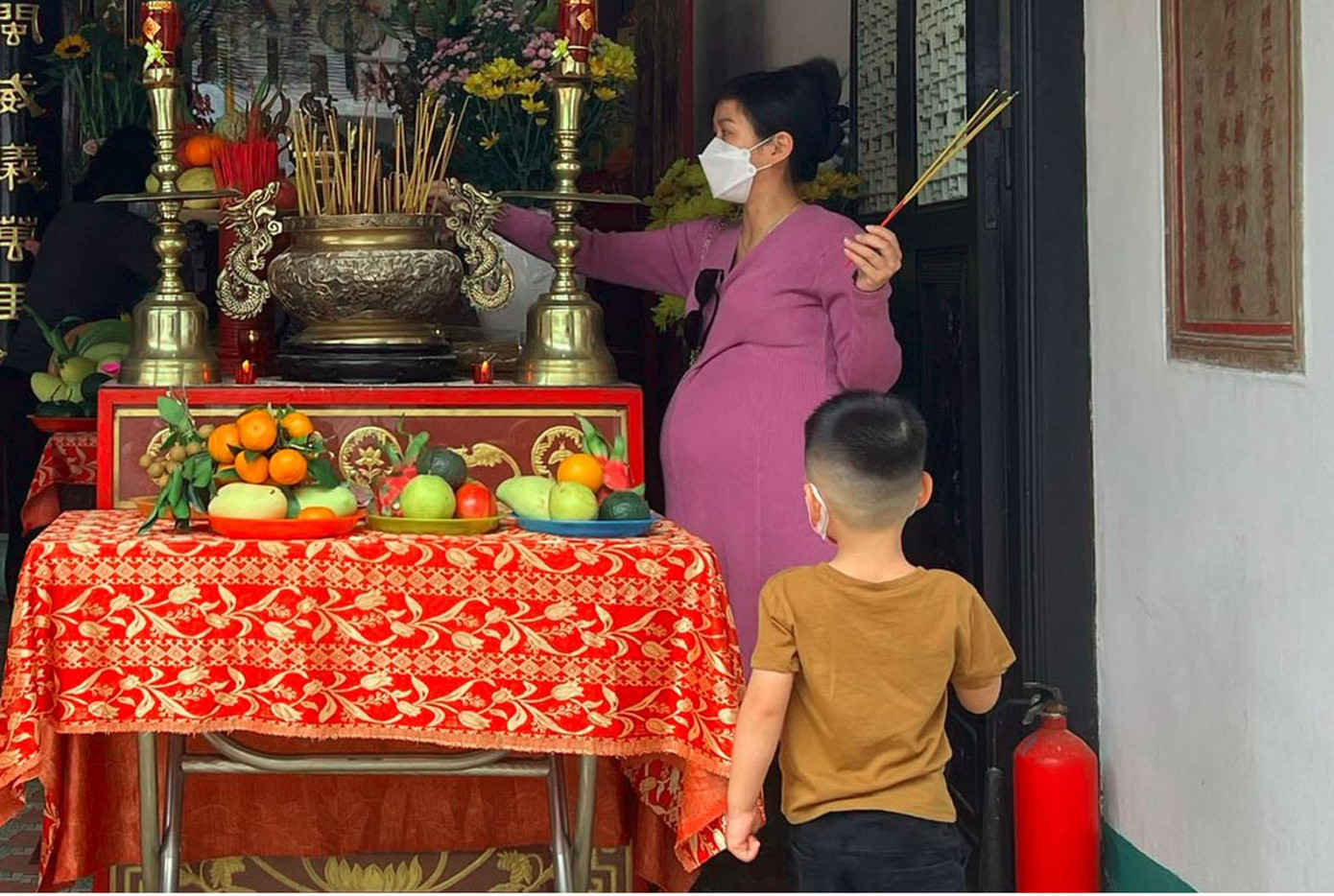 Phụ nữ mang thai đến viếng ngày lễ sẽ cầu cho khi đứa trẻ ra đời được mẹ tròn, con vuông - Ảnh: Bảo Quyên