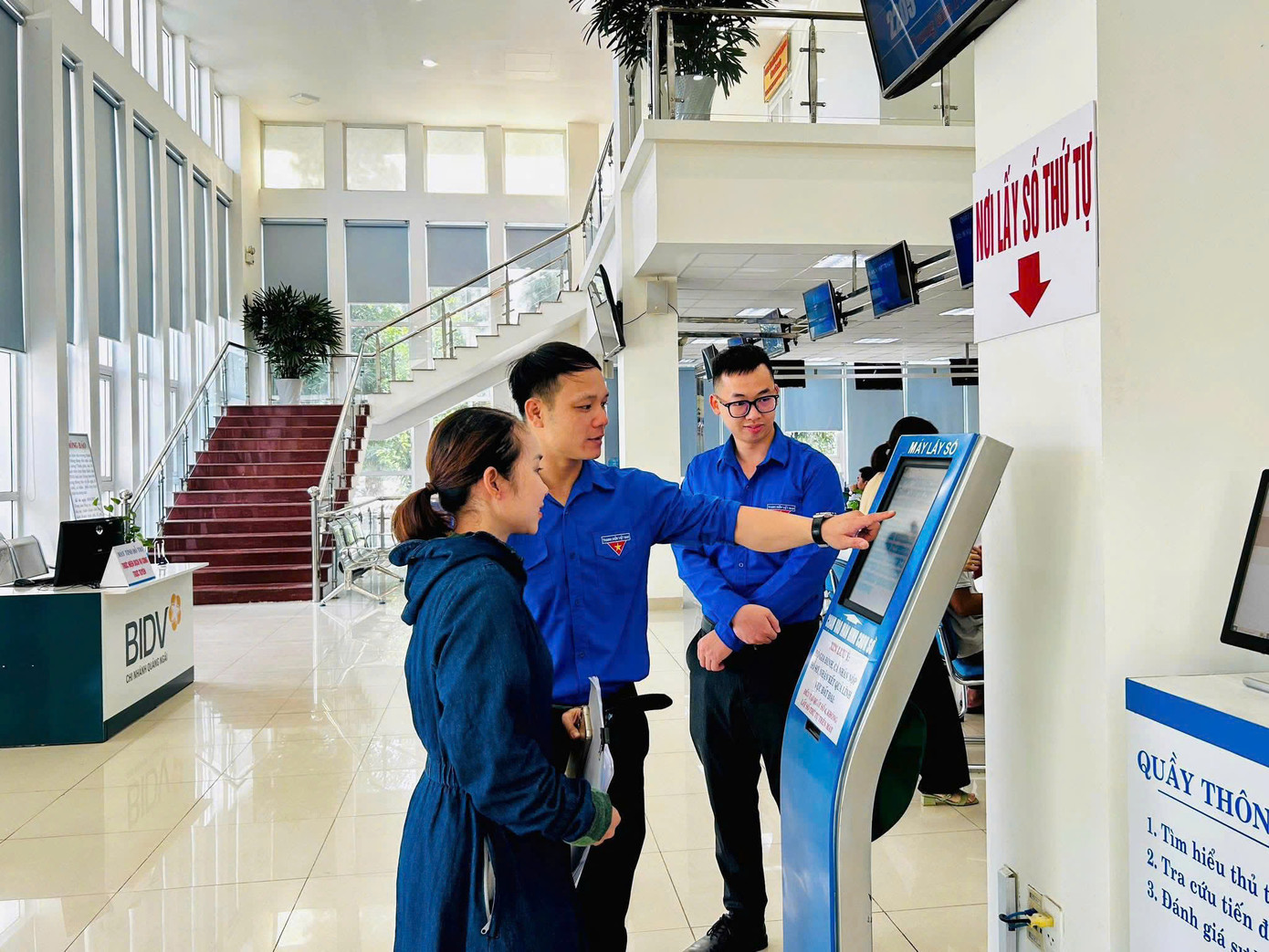 Các đội hình thanh niên tình nguyện phối hợp với lực lượng chức năng hỗ trợ người dân sử dụng các dịch vụ công trực tuyến. Ảnh: Nguyễn Ngọc