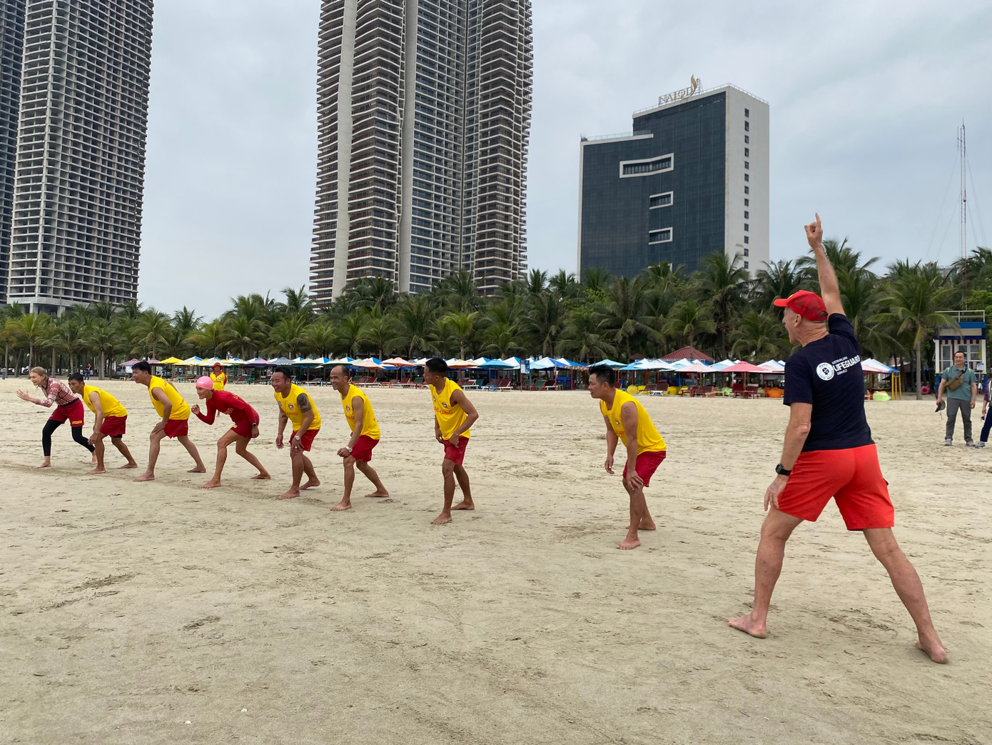 Ông David Field (áo đen) và một số tình nguyện viên trong Hiệp hội Cứu hộ Úc cùng Đội cứu hộ bãi biển Đà Nẵng thực hiện những bài tập cứu hộ. - Ảnh: Phượng Nhung