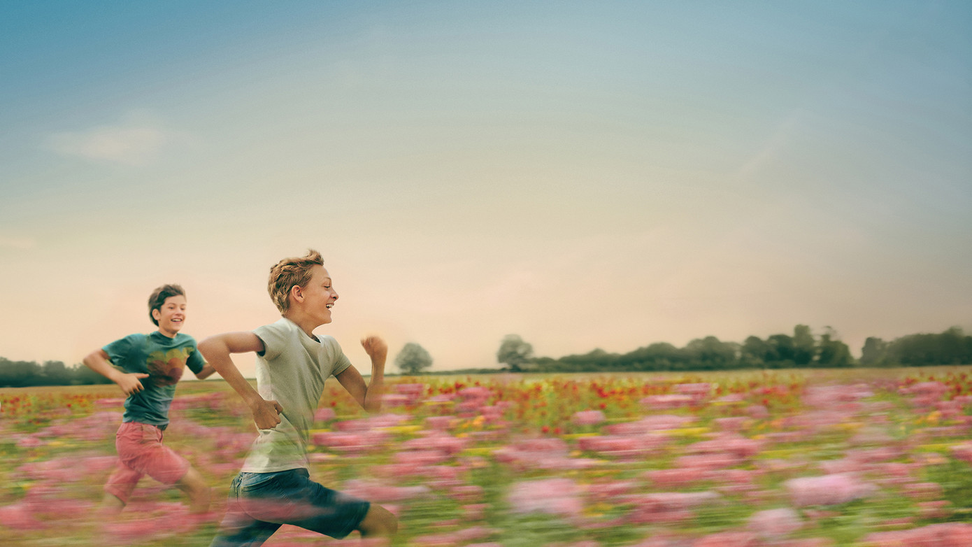 Đôi bạn thân chạy thoăn thoắt qua cánh đồng hoa rực rỡ sắc màu.