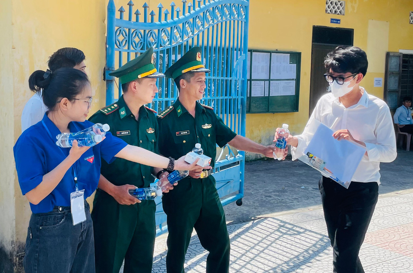 BĐBP và các ĐVTN phát nước uống, động viên thí sinh tại điểm thi Trường THPT Thuận An. Ảnh: Văn Chương