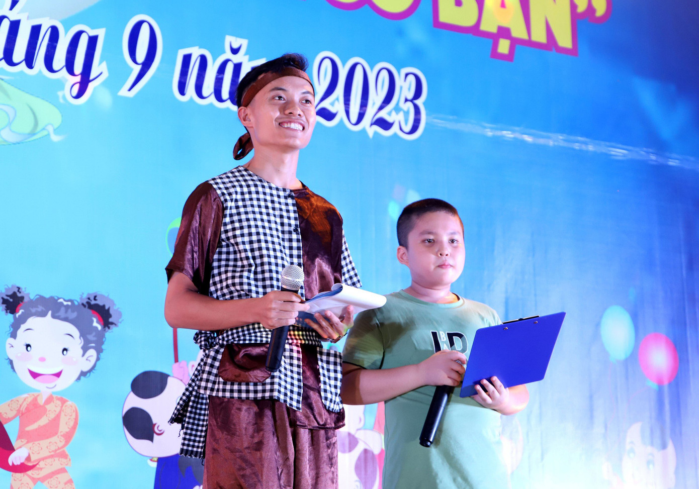 Em Trần Trung Hiếu (bên phải) có bố đang thực hiện nhiệm vụ trực trên biển phát biểu cảm tượng tại chương trình. (Ảnh: Hoàng Diệu)