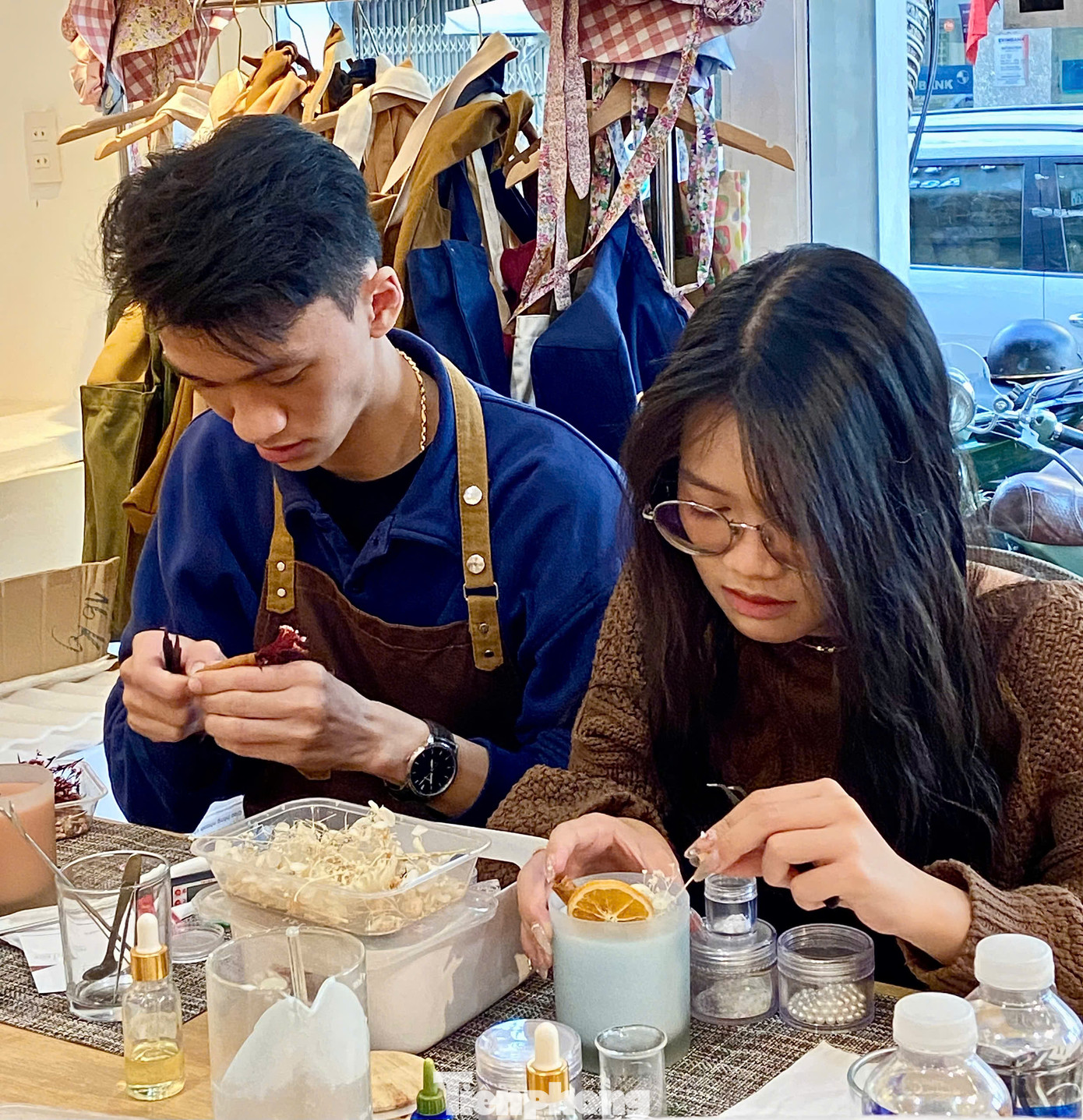 Nhiều cặp đôi khác cũng tận hưởng khoảnh khắc ngọt ngào khi cùng nhau tạo ra những cốc nến thơm đầy ý nghĩa tại workshop. Ảnh: Ngọc Thắm.