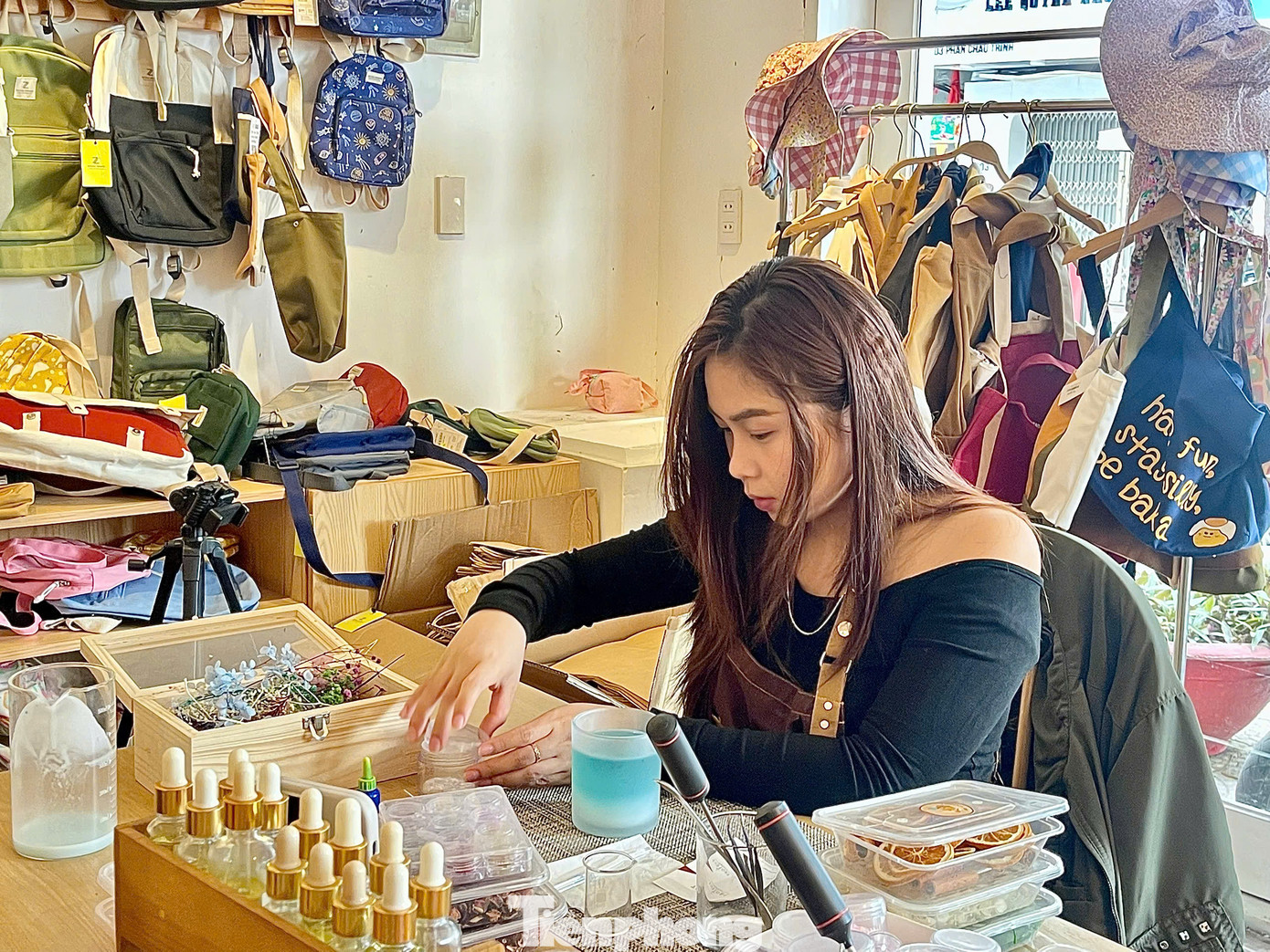 Chị Minh Thư 26 tuổi đang cẩn thận chuẩn bị món quà bất ngờ cho bạn trai ở phương xa. Chị Thư cho biết mình và bạn trai đã gắn bó suốt 4 năm, nhưng hiện tại phải yêu xa. Chị tự tay làm một hộp nến thơm, mong rằng món quà nhỏ bé này sẽ mang hơi ấm tình yêu đến với anh nơi xứ sở hoa anh đào lạnh giá. "Mình hy vọng khi nhận được món quà này, anh ấy sẽ cảm nhận được không chỉ hương thơm dịu dàng mà còn cả tình cảm mình gửi gắm trong đó. Mỗi lần thắp nến lên, mình mong rằng anh sẽ nhớ đến những khoảnh khắc chúng mình đã bên nhau, dù cách xa nhưng trái tim vẫn luôn gần gũi", chị Thư xúc động chia sẻ. Ảnh: Ngọc Thắm